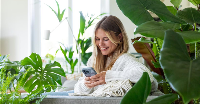 Jungle Ambiente - Frau mit Handy auf dem Sofa